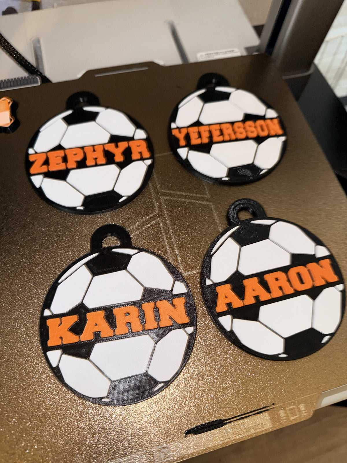 Actual personalized black white and orange soccer ball name tags